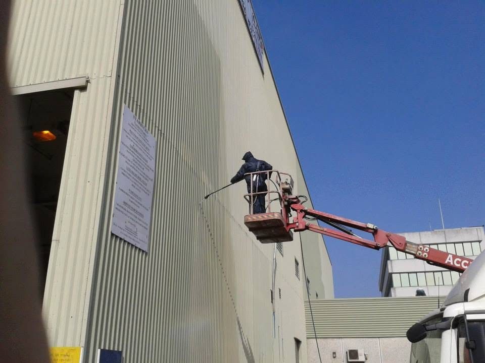 Warehouse exterior wash from a cherry-picker